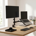 Modern office setup with a monitor, laptop, keyboard, and mouse on a wooden desk.