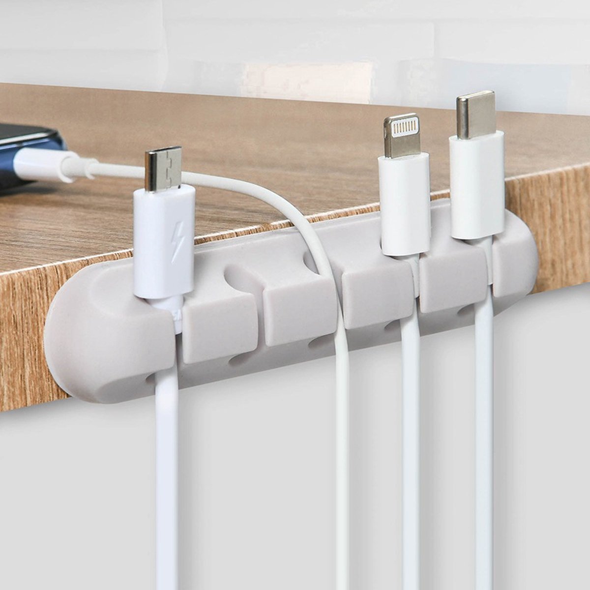 White cable clips organising cables under desk edge