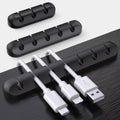 Black cable clips organising cables under desk edge